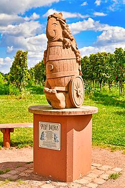 Wiesloch, Germany, August 2021: Funny sculpture of wine god called 'Speedy Bacchus' with blurry vineyard in background, Europe