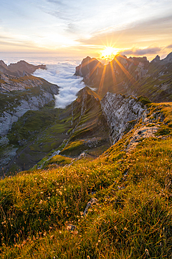 View over Saentis mountains into the valley of Meglisalp at sunrise, sun star, Rotsteinpass, high fog in the valley, Saentis, Appenzell Ausserrhoden, Appenzell Alps, Switzerland, Europe