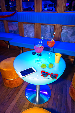 Glasses of glasses on a reserved table at a night party in a disco on vacation