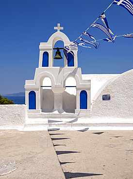 White bell tower with Greek flags, Chapel of Transfiguration of Sotiros Christos, Ia, Oia, Santorini, Greece, Europe