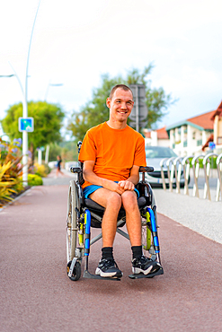 Portrait of a very cheerful disabled person in a wheelchair at the beach on vacation