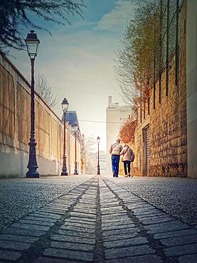 Senior couple walking outdoors together. Healthy lifestyle, elder love concept. Happy old pair strolling on the town alley in Asnieres sur Seine, a Paris suburb, France, Europe