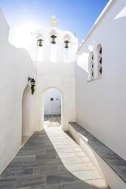 Archway with bells of the Greek Orthodox Chapel of Agios Antonios, with sun star, alleys of the village of Marpissa, Paros, Cyclades, Greece, Europe