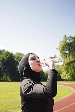 Woman drinking water from plastic bottle