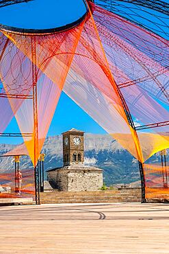 Colored arch in the Ottoman Castle Fortress of Gjirokaster or Gjirokastra and in the background the church with the clock tower. Albania, Kulla e Sahatit