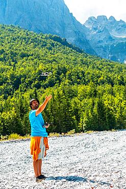 Drone pilot man taking off exploring new places in the mountain. Use of drone photography