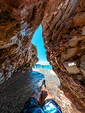 Sitting on the paradise beach of Kroreza or Krorez in a cave on the Albanian riviera in Sarande, Albania, Europe