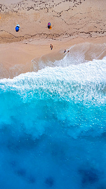 Aerial drone aerial shot in summer on paradise sandy beach Megali Petra in Lefkada. Beautiful crystal clear turquoise and blue waters. Greece. vertical photo