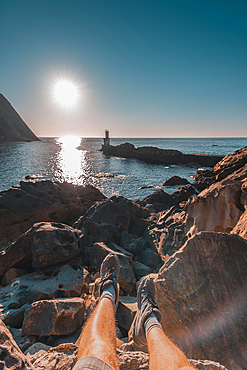 Feet of a young man sitting at the Lighthouse in Pasajes San Juan near San Sebastian, Guipuzcoa. Basque Country