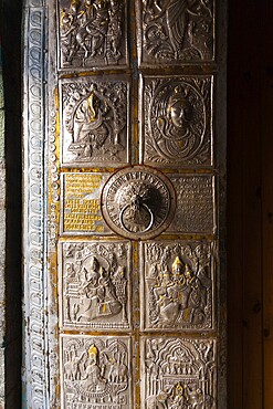 The ornamental metal door entrance to Bhimakali Temple covered in inscriptions and reliefs in Sarahan, Himachal Pradesh, India. Vertical