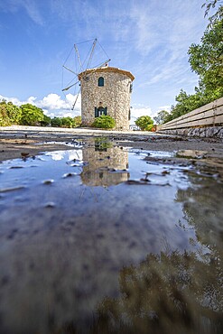 Great typical Greek windmill in the evening. In the Mediterranean architectural style of Greece. It stands on a cliff in the Mediterranean. Potamitis windmill, Ionian Islands, Greece, Europe