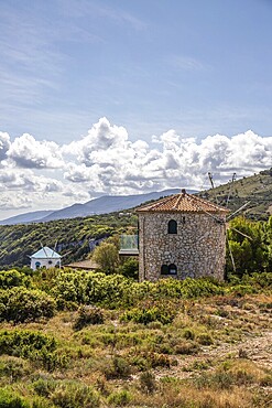 Great typical Greek windmill in the evening. In the Mediterranean architectural style of Greece. It stands on a cliff in the Mediterranean. Potamitis windmill, Ionian Islands, Greece, Europe