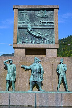 Sjomannsmonumentet south side monument to seafarers shows three historical figures, with a detailed relief in the background under a blue sky, Bergen, Vestland, Norway, Europe