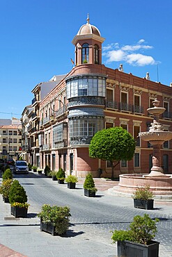 Historic building with bay window on an urban street with fountain and trees under a blue sky, Casa Bouderé, House Boudere, Antequera, Malaga, Andalusia, Spain, Europe