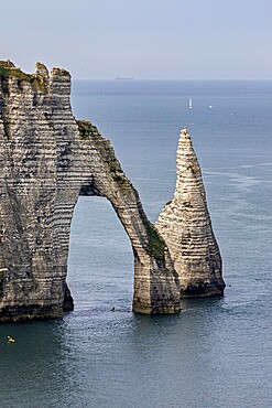 Iconic rock formation with natural arch over the blue sea, The cliffs and alabaster coast of Etretat in Normandy France