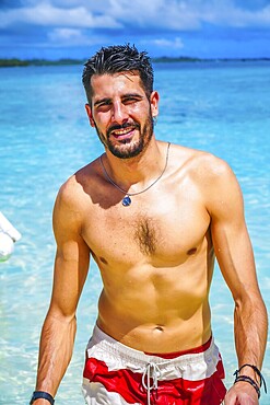 Young man enjoying summer holidays in the turquoise tropical sea of naked island, siargao, philippines