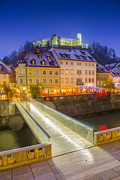 View of houses on the Ljubljanica River and Ljubljana Castle at dusk, Ljubljana, Slovenia, Europe