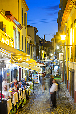 View of cafes in cobbled street in old town at dusk, Funchal, Madeira, Portugal, Europe