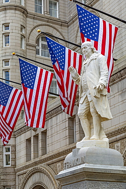 View of Benjamin Franklin statue and US flags in front of former Old Post Office Pavilion, Washington D.C., United States of America, North America