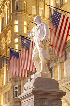 View of Benjamin Franklin statue and US flags in front of former Old Post Office Pavilion, Washington D.C., United States of America, North America