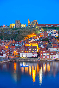 View of St. Mary's Church and Whitby Abbey from across River Esk at dusk, Whitby, Yorkshire, England, United Kingdom, Europe