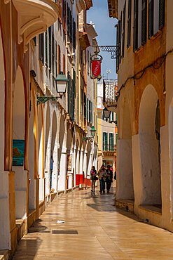 View of pastel coloured arcades in narrow street, Ciutadella, Memorca, Balearic Islands, Spain, Europe