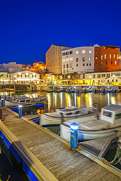 View of boats in marina overlooked by whitewashed buildings at dusk, Ciutadella, Menorca, Balearic Islands, Spain, Mediterranean, Europe