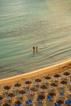 View of couple in sea and sunshades on Platja de Cala Galdana in Cala Galdana, Cala Galdana, Menorca, Balearic Islands, Spain, Mediterranean, Europe