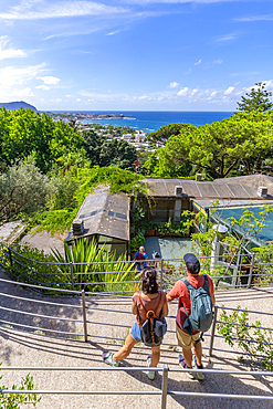 View of man and woman in Giardini la Mortella Botanical Garden and Forio in background, Forio, Island of Ischia, Campania, Italy, Europe