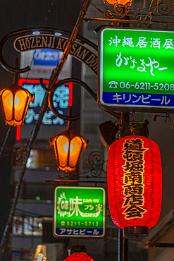 View of colourful signs in backstreet in Dotonbori, vibrant entertainment district near the river, Osaka, Honshu, Japan