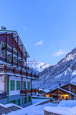 View of chalets and snow covered mountains in Courmayeur before dawn during winter, Courmayeur, Aosta Valley, Italy, Europe