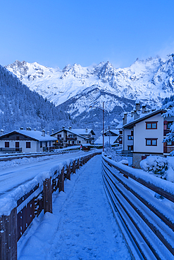 View of chalets and snow covered mountains in Courmayeur before dawn during winter, Courmayeur, Aosta Valley, Italy, Europe