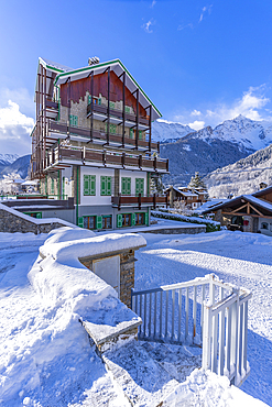 View of chalets and snow covered mountains in Courmayeur at sunrise during winter, Courmayeur, Aosta Valley, Italy, Europe