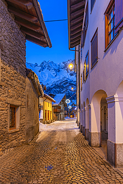 View of town centre and snow covered mountains in background at dusk, Courmayeur, Aosta Valley, Italy, Europe