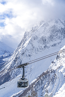 View of snow covered Aosta Valley, mountains and Skyway Monte Bianco cable car in winter, Courmayeur, Aosta Valley, Italy, Europe