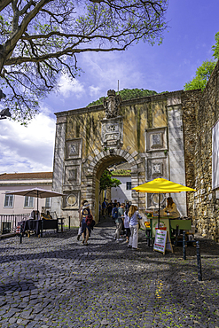 View of stall and Arco do Castelo, entrance to Lisbon Castle, Alfama District, Lisbon, Portugal, Europe