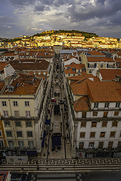 View of city rooftops and Lisbon Castle from Santa Justa Lift during golden hour, Lisbon, Portugal, Europe