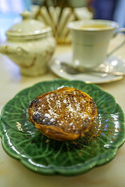 View of Pastel de Nata, Portuguese custard tart on green plate in cafe in the Alfama District, Lisbon, Portugal, Europe