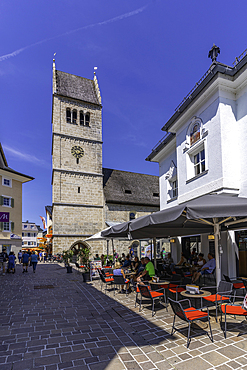 View of St. Hippolyte Church and cafe in Zell am See on a sunny day, Zell am See, Salzburg, Austria, Europe