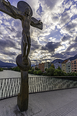 View of Rudi Wach Kreuz sculpture on bridge and colourful buildings at sunset in summer, Innsbruck, Tyrol Region, Austria, Europe