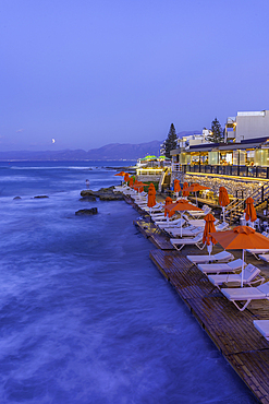 View of taverna overlooking the sea in Limenas Chersonisou at dusk, Crete, Greek Islands, Greece, Europe