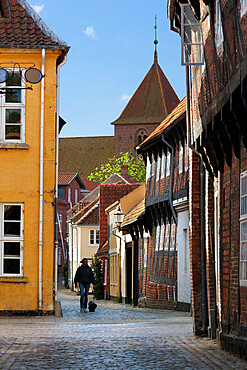 Cobblestone alley in the old town with tower of St. Catharinae Kirke, Ribe, Jutland, Denmark, Scandinavia, Europe