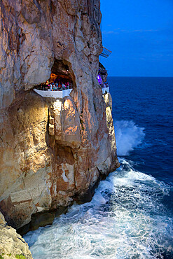 Bar built in cliff caves, Cova d'en Xoroi in evening, Cala en Porter, Menorca, Balearic Islands, Spain, Mediterranean, Europe