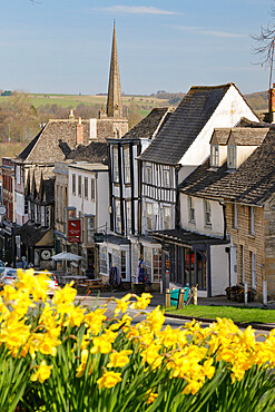 High Street and Burford Church with daffodils, Burford, Cotswolds, Oxfordshire, England, United Kingdom, Europe