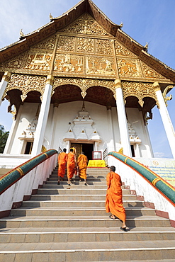 Buddhist monks climbing stairs to a temple at the Pha That Luang, Vientiane, Laos, Indochina, Southeast Asia, Asia