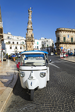 Tuk-tuk in Piazza della Liberta with Colonna di Sant Oronzo column, Ostuni, Brindisi province, Puglia, Italy, Europe