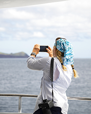 Tourist enjoying view from yacht, Isla Bartholomé, Galapagos Islands, Ecuador