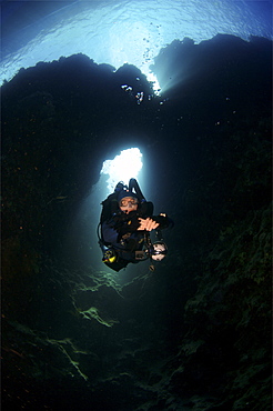 Mixed gas rebreather diver appearing from an underwater arch  Red Sea.