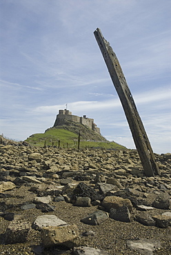 Holy Island or Lindisfarne Castle (view from shore with posts from old ruined pier), Holy Island, Northumberland, UK.