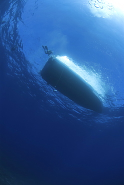 Dive boat silhoutte against surface, Cayman Islands, Caribbean